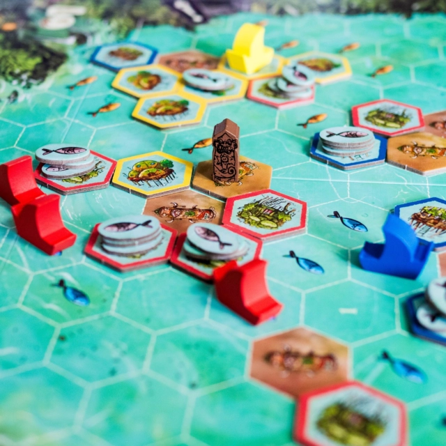 🔸Feya's Swamp 🔸
(Fr & En)

@matagot.france @grailgames

👀 Comment on joue ?

Feya’s Swamp est un jeu de gestion, de développement territorial et de majorité pour 2 à 4 joueurs, créé par Helge et Anselm Ostertag

Une partie se déroule en 4 manches, elles-mêmes divisées en 3 phases.

1. Phase de revenus
Au début de chaque manche, chaque joueur reçoit les ressources indiquées sur son plateau personnel ainsi que les éventuels bonus de son guide.

2. Phase de jeu
Les joueurs jouent chacun leur tour selon l’ordre d’initiative déterminé par leur guide.

À son tour, un joueur choisit l’une des trois options suivantes :

💠Effectuer une action maritime :

➡ Pêcher
Les bateaux se déplacent vers des zones contenant le poisson de saison. Chaque bateau rapporte un nombre de poissons dépendant de votre capacité de pêche.

➡ Construire une colonie
Les bateaux rejoignent une zone constructible. Il place alors une nouvelle tuile de colonie provenant de son plateau personnel et débloque souvent de nouveaux bonus.

➡ Commercer
Les bateaux accostent près de colonies. Le joueur dépose des poissons sur les colonies voisines.

- sur les colonies adverses pour gagner de l’or ;
- sur ses propres colonies afin de préparer les futurs festivals.

➡ Naviguer
Cette action permet simplement de déplacer ses bateaux. C’est également le moyen d’explorer les temples situés aux extrémités du plateau et d’obtenir leurs récompenses.

💠Effectuer une action terrestre

➡ Améliorer sa navigation
Le marqueur de navigation progresse sur la piste.

➡ Organiser une célébration
Le joueur choisit une île. Chaque colonie contenant du poisson rapporte des points. Enfin, tous les poissons de l’île sont retirés.

➡ Ajouter un esprit
Le joueur place une nouvelle tuile Esprit sur le plateau.

3. Phase de maintenance
Les joueurs récupèrent leurs ouvriers, la carte de saison des poissons change, et on réorganise l’ordre du tour.

🔶 Fin de partie
Après la 4e manche, on passe au grand décompte final.
.
.
.
Copie presse