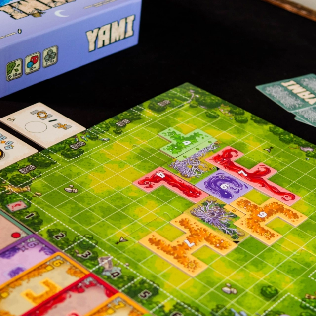 @musokastudio 

YAMI — C’EST QUOI ?

Yami est une aventure coopérative originale qui mélange jeu de plis et placement de tuiles polyominos.

COMMENT ON JOUE ?

Une mission se déroule en 7 manches maximum. Votre objectif : réussir à entourer complètement les tuiles Mission avant la fin de la septième manche.

Chaque manche se déroule en 4 phases :

🃏 Détermination de la carte Décision
🃏 Jeu du pli
🧩 Sélection et placement de la tuile Esprit
🎯 Vérification des conditions de réussite

🃏 Le jeu de plis

Chaque joueur possède des cartes Esprit numérotées de 1 à 7, réparties dans 5 couleurs.
Le premier joueur joue une carte et les autres doivent suivre la couleur demandée s’ils le peuvent. La carte de plus forte valeur remporte le pli… sauf si une carte Atout est jouée !

🔄 La carte Décision

La carte gagnante devient la carte Décision.
Elle permet de déterminer la tuile Esprit récupérée, mais également la couleur d’Atout du pli suivant.

🧩 Les tuiles Esprit

Une fois le pli remporté, les joueurs récupèrent la tuile correspondant à la carte Décision.

Il faut ensuite la placer intelligemment sur le plateau.

🎯 Entourer les missions

Pour réussir, il faut entourer complètement les tuiles Mission avec les tuiles Esprit.

Toutes les cases directement adjacentes aux côtés de la tuile doivent être recouvertes. Certaines missions ajoutent également des contraintes supplémentaires, comme l’obligation de respecter certaines couleurs.

⏳ 7 manches, pas une de plus !

Si les conditions ne sont pas remplies à la fin de la septième manche, la mission est perdue.

🌙 UNE CAMPAGNE QUI ÉVOLUE

Yami propose 22 missions avec du matériel qui se débloque progressivement.

Des enveloppes mystères introduisent notamment de nouveaux pouvois, tandis que le Chemin de la Lune ajoute progressivement des désavantages permanents.

💬 Alors, Yami 'est bien ?

Yami mélange avec originalité jeu de plis, placement de tuiles et communication limitée, avec une alchimie entre ces mécaniques qui fonctionne particulièrement bien. Sa campagne de 22 missions et ses enveloppes mystères donnent envie de progresser, malgré une certaine répétitivité.

La note : 7.5/10

L'avis complet sur le site.
